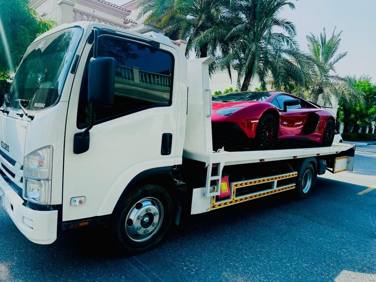 Red Lamborghini Aventador SV on a flatbed tow truck