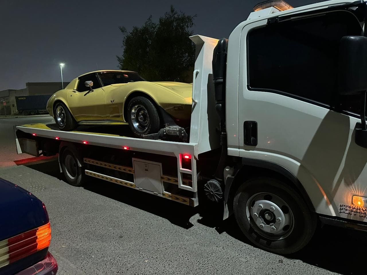Classic Chevrolet Corvette on a flatbed at night